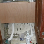 Test fitting the piece of wood to cover the holding tank